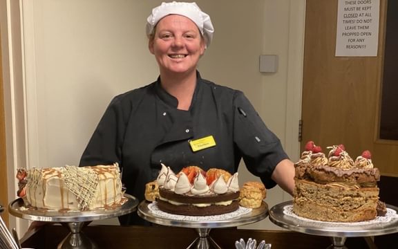 Care Home chef with cakes on a high tea trolley
