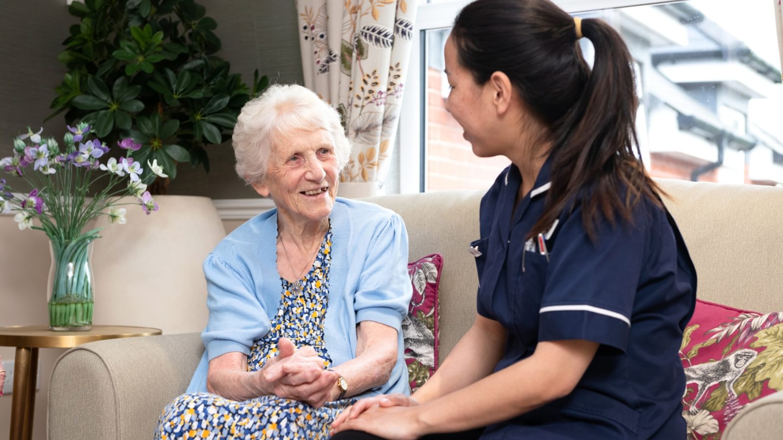 Resident in care home sitting with nurse