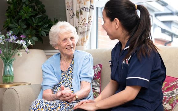 Resident in care home sitting with nurse