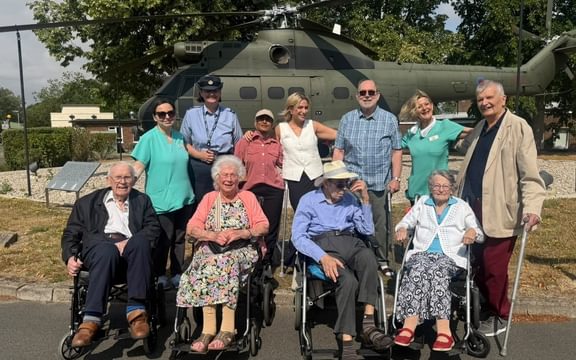 Group of care home residents in front of a helicopter at RAF Benson