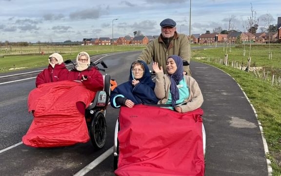 Benson House residents on the road in a trishaw with Cycling Without Age