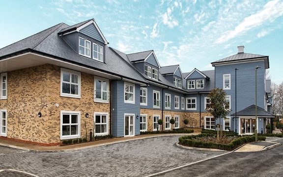 Outside of Benson House Care Home in Oxfordshire with double doors leading to reception and bedrooms to rooms