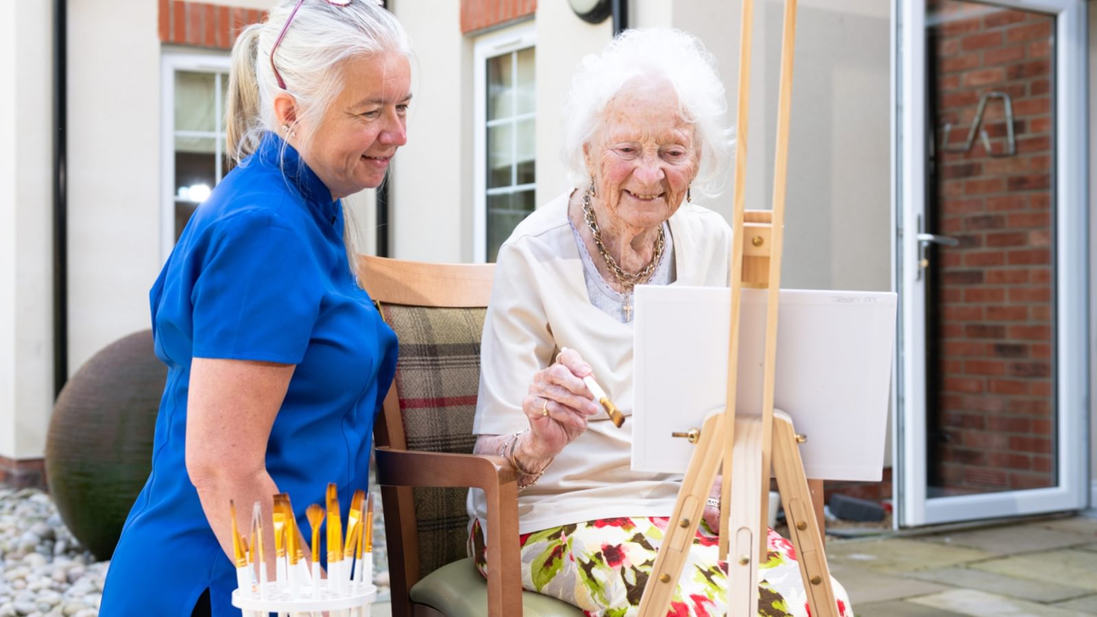 Blenheim Court Care Home Resident painting with carer in the garden