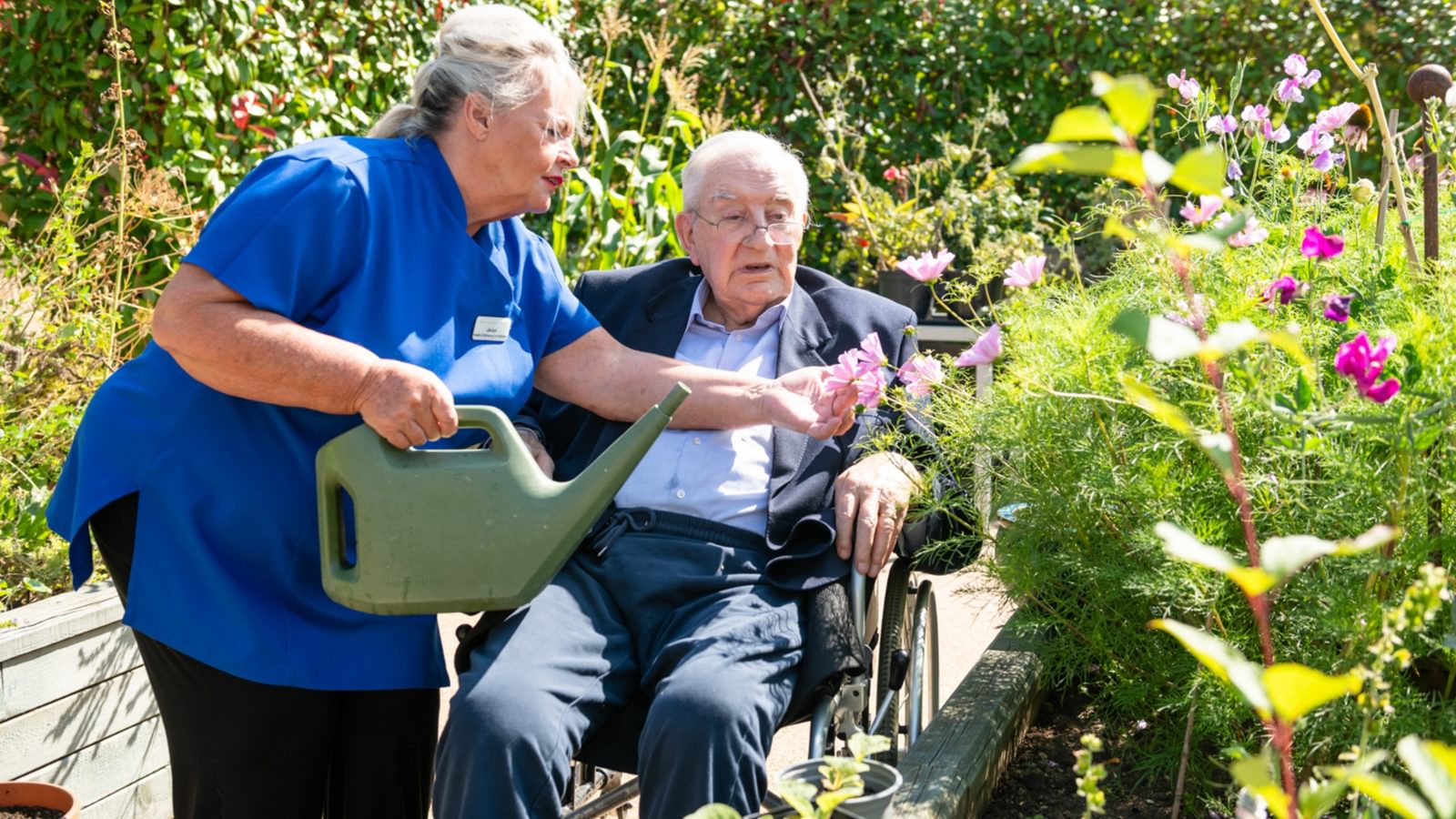 Blenheim Court Care Home Resident watering plants with activities lady