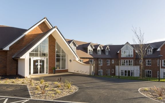 Exterior of Blenheim Court Care Home in Liss with doors to reception