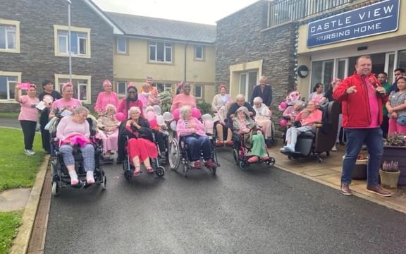 Team and residents taking part in the Castle View Wheelchair Dash to raise money for the Manx Cancer Charity