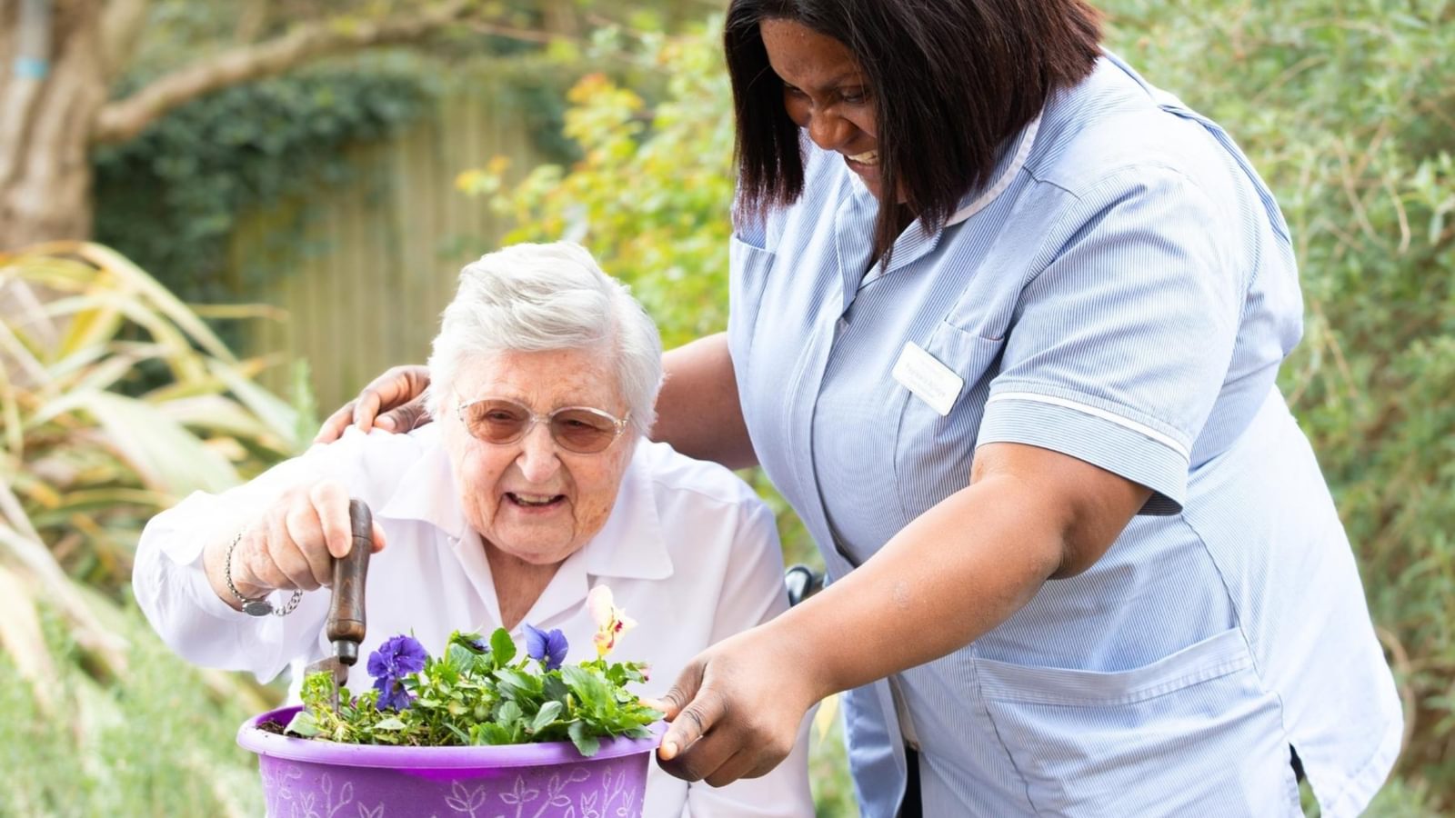 Care Home resident with carer doing gardening