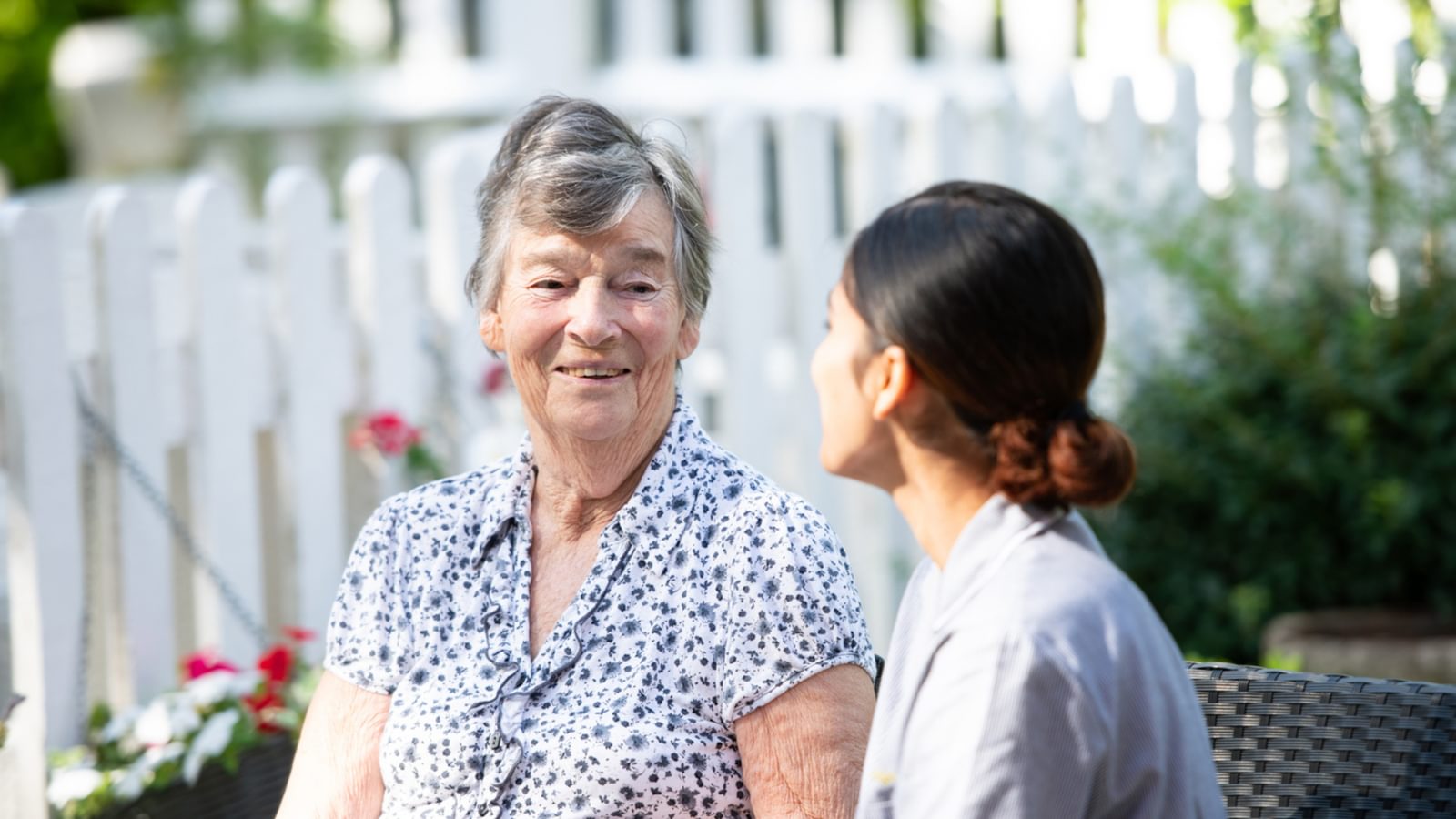 Resident and carer in a garden in a care home setting