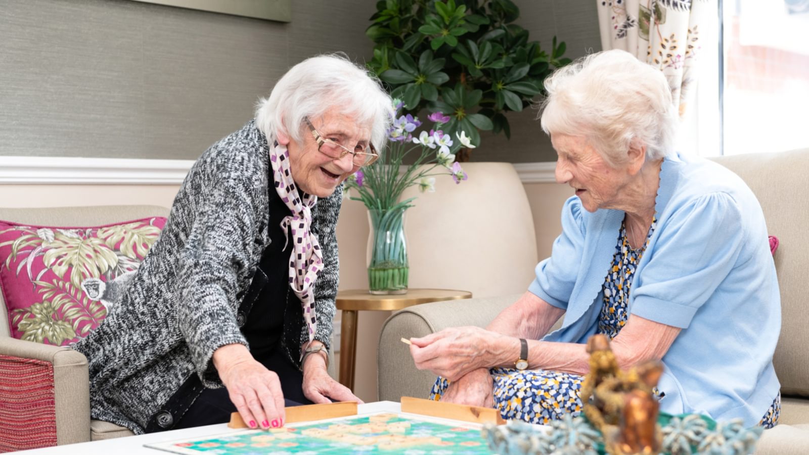 Female residents playing scrabble in a care home