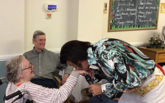 Care home resident kissed on the hand by Elvis impersonator
