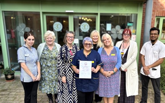 Care home team members pose with a certificate of continuous improvement from the Veteran Friendly Framework