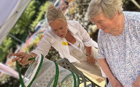 Resident and relative look at butterflies in a mesh house