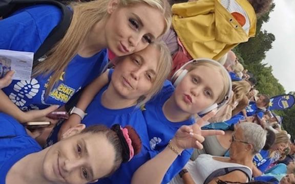 Angled shot of 4 females in blue t-shirts after completing a charity walk