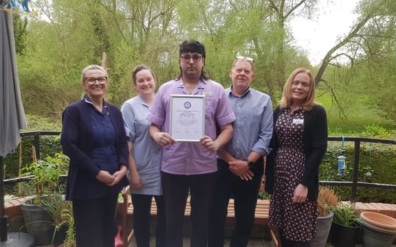Care home team pose with their framed Veteran Friendly Framework certificate