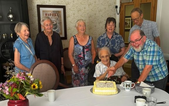 Care home resident and husband cut Diamond Wedding anniversary cake with group of friends