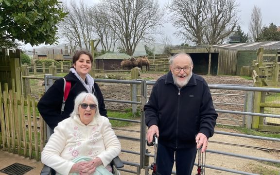Two care home resident and a wellbeing team member on a trip to the zoo