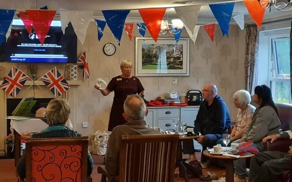 Trainer presents to group of participants in room decorated with triangular flags