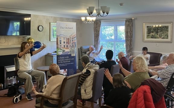 Care home residents take part in a chair yoga session