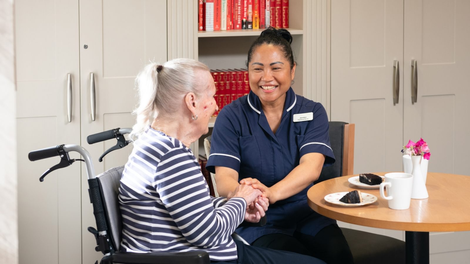 Female resident sitting with a nurse in a care home setting