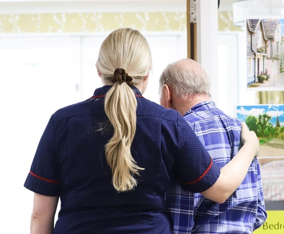 Caring Homes staff member comforts a resident living with dementia.