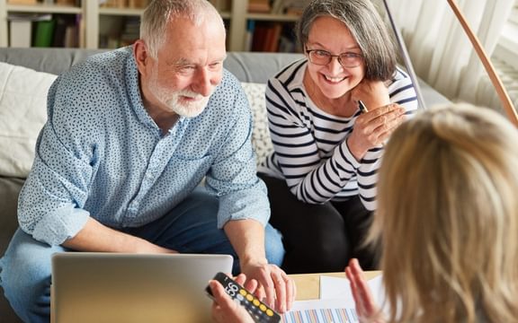 Care seekers speaking to a financial planning expert specialising in care home and elderly care finances in a care home event for Caring Homes