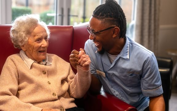 A care resident with a care assistant in a Caring Homes lounge area