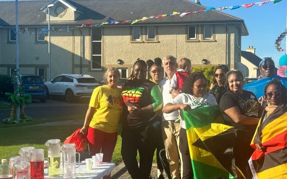 Team members at Castle View in Peel draped in national flags from across the world celebrate different cultures