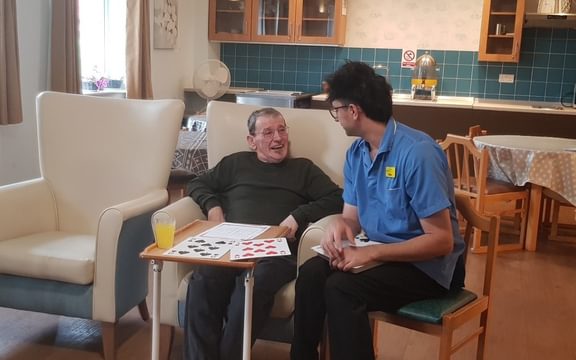 Mellish House Care Home in Sudbury Resident Michael enjoying playing a game with welcoming carer