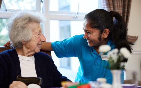UK nursing home carer talking with a resident.