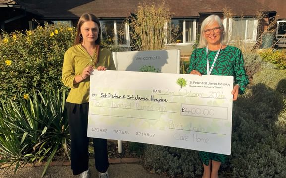 Wellbeing Coordinator from Parris Lawn Care Home in Ringmer, East Sussex presents cheque to St Peter & St James Hospice in Haywards Heath
