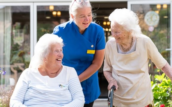 Loneliness Awareness week - 2 residents smiling with a Carer at a Caring Homes Group care home