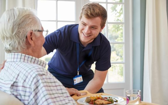 Care home team member talking with an elderly resident