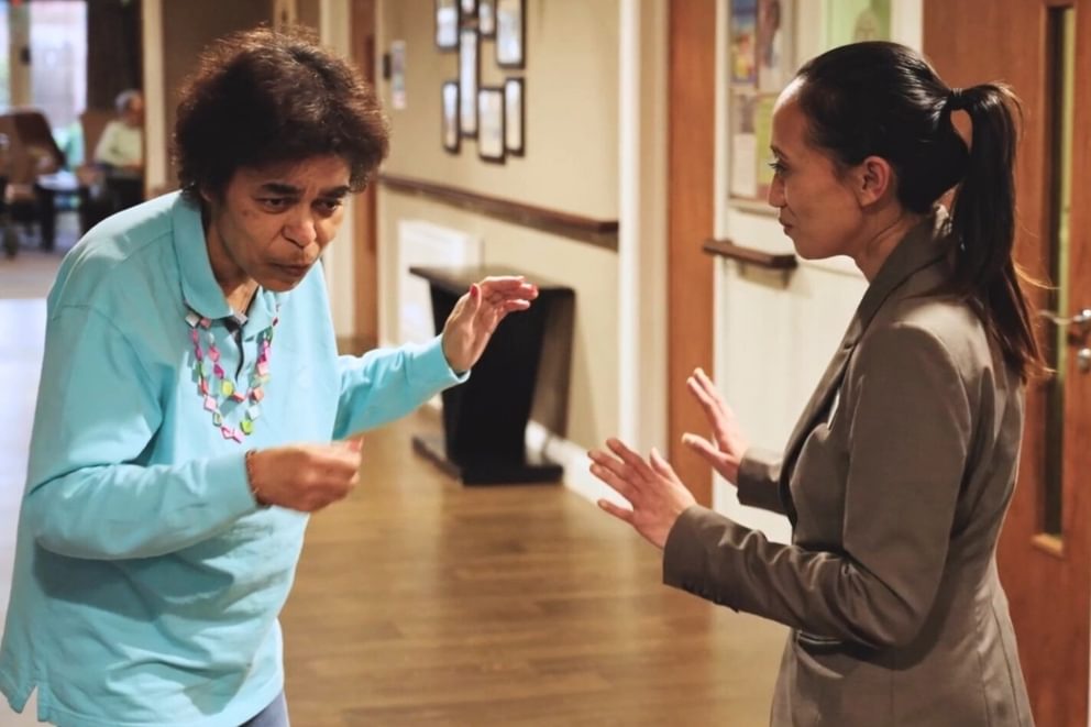 Resident dancing with staff member in a care home