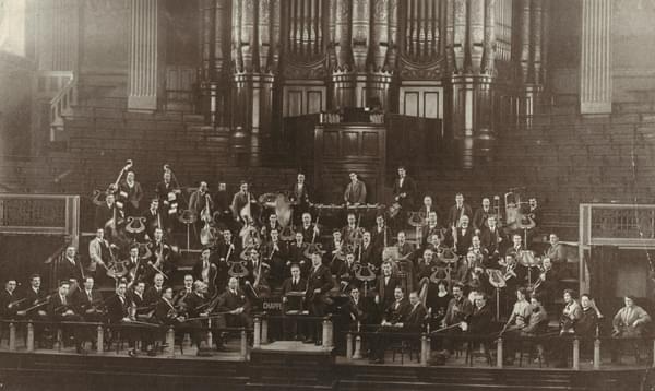 Old black and white photograph of the orchestra's founding members in 1920, in front of the organ at Birmingham Town Hall