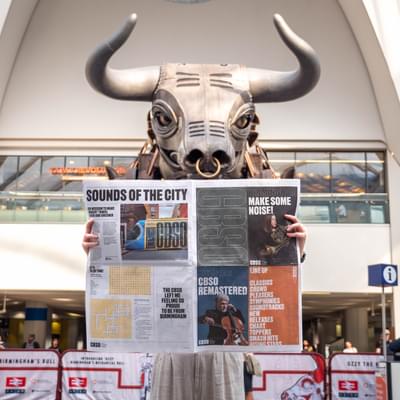 Photograph of Ozzy the Bull reading the CBSO Newspaper
