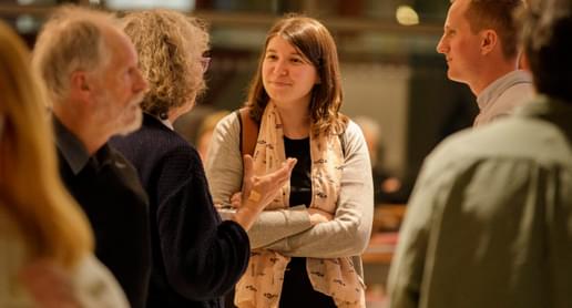 Photograph of a young woman talking to friends in Symphony Hall's foyer