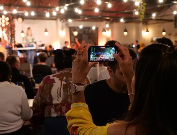 A photograph of a woman using her phone to take a picture at Hockley Social Club