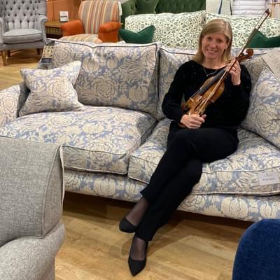 Violinist Jane Wright sat on a blue and white patterned sofa