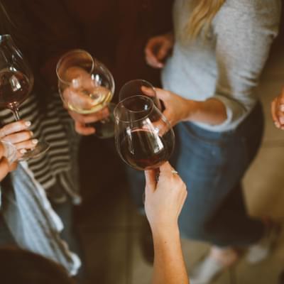 Photograph of people holding glasses of wine.