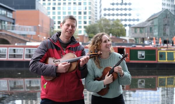Photograph of Adam Romer and Kirsty Lovie with their instruments on the Birmingham canal