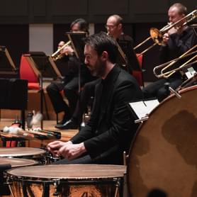 Photograph of Matthew Hardy playing the timpani on-stage at Symphony Hall