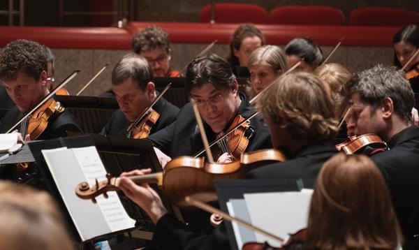 Photograph of Peter Campbell-Kelly playing in the violin section in Symphony Hall