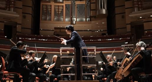 Photograph of Kazuki Yamada conducting the orchestra at Symphony Hall