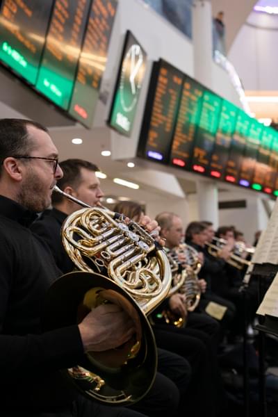 Photograph of Jeremy Bushell playing the French Horn at New Street station
