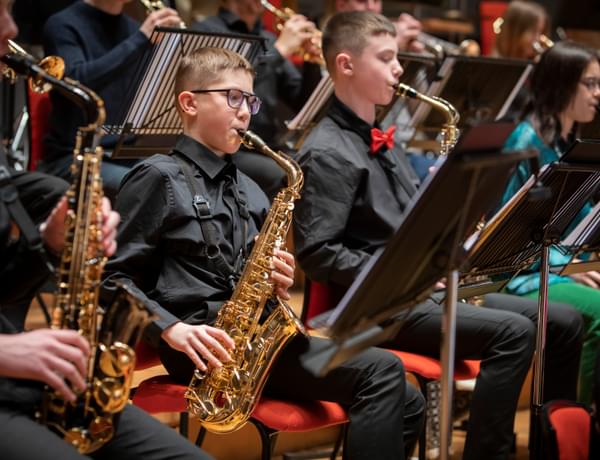 Photograph of a group of boys playing the saxophone