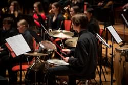 Photograph of a teenage boy playing a drumkit during a Project Remix performance at Symphony Hall