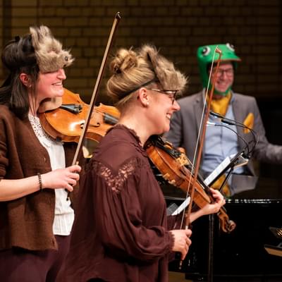 Photograph of Charlotte Skinner and Jessica Tickle playing whilst wearing animal masks during a Relaxed Concert