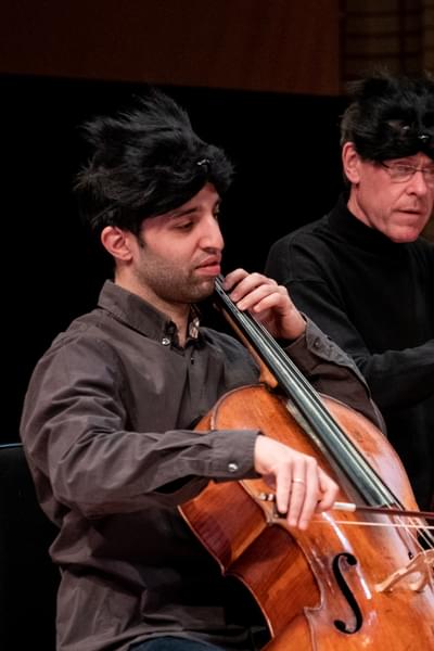 Photograph of Miguel Fernandes playing the cello whilst wearing an animal mask at a Relaxed Concert