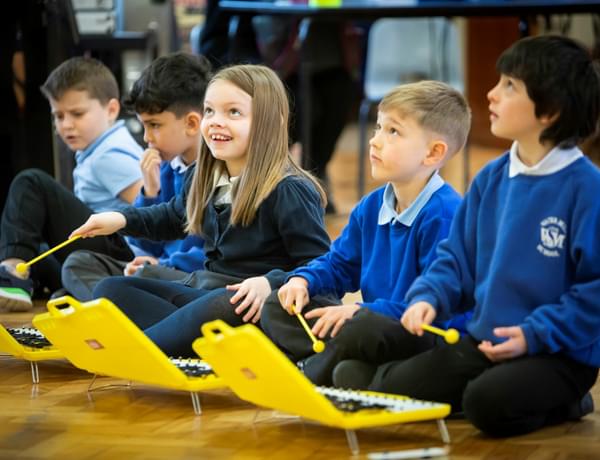 Photograph of children in school uniform playing on glockenspiels