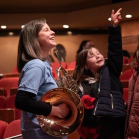 Photograph of French Horn player Elspeth Dutch talking with children